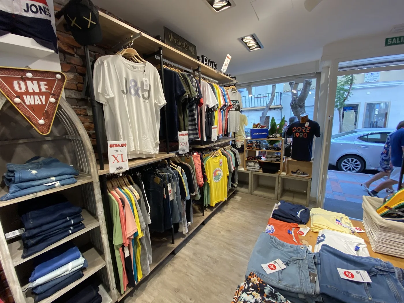 Señal ONE WAY y percheros dentro de la tienda